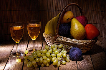 Gifts of nature, on a beautiful background, glasses of homemade wine and apples, grapes, plums.