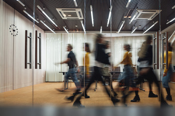 Group of office employees at coworking center. Business people walking at modern open space. Motion...