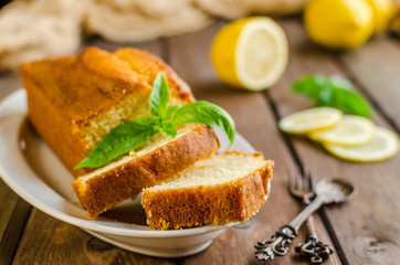 Lemon pound cake on rustic wooden background with lemon.
