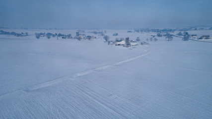 Aerial View of Fresh Followed Morning Snow over an Amish Countryside and Farm Land as Seen by a Drone