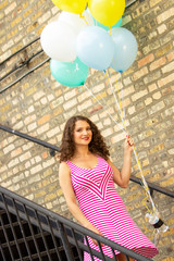 woman holding balloons on stairs 