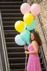 woman holding balloons on stairs 