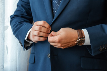 Hands of a businessman, close-up, buttons on a jacket. Concept of business style.
