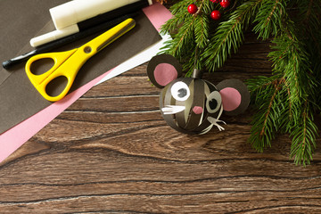 Merry Christmas gift on a wooden table - a symbol of the gift of 2020, Christmas toy mouse made of Kraft paper. Handmade. The project of children's creativity, crafts, crafts for children.
