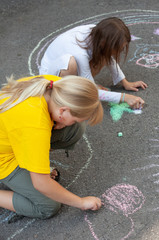 Fototapeta premium little girls draws on asphalt