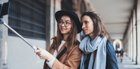 Smile girlfriends taking photo selfie on smartphone internet mobile. Blogger hipster travels in Barcelona. Holiday friendship concept. Travelers self cellphone internet technology mockup space