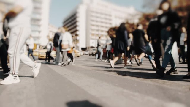 Pedestrians and shoppers commuting in the city on a busy bright day crossing the intersection. No logos trademarks or faces visible.10 bit original BMPCC clip.