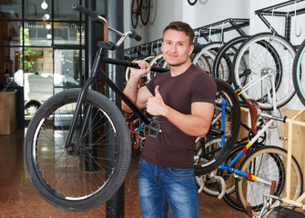 man who is standing smile with bicylce
