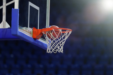A basketball flies into the ring. On the background of a sports complex