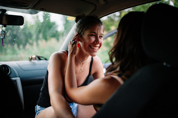 Two young lesbians enjoying inside a car