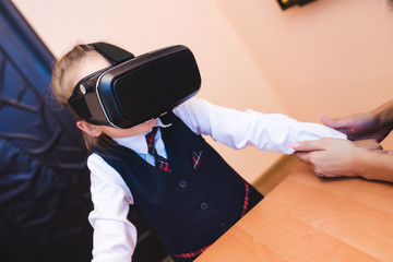 Children with virtual reality glasses are in the school office. Modern teaching methods