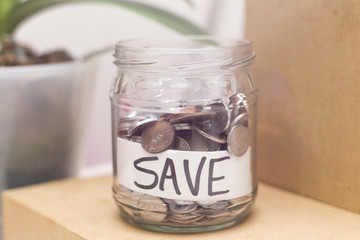Jar with coins and inscription SAVE. Economy and finance prosperity concept. Saving income and...