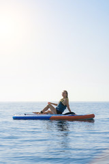 Summer holidays vacation travel. SUP Stand up paddle board. Young woman sailing on beautiful calm lagoon