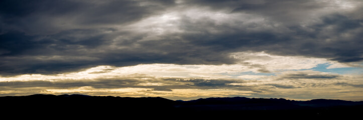 dark clouds at sunset over the hills