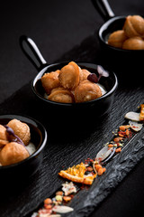 Mini dumplings on a beautiful dish on a dark background. Food concept for catering. Low key, copy space.