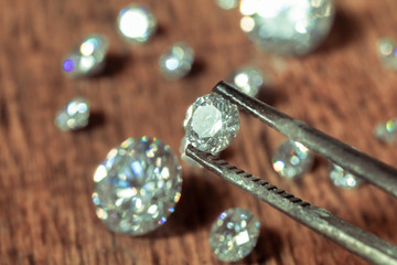 brilliant cut diamond held by tweezers