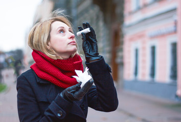 A sick woman drips her nose, drops from nasal congestion with colds and flu. A diseased walks down...