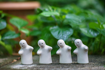 White ceramic doll Against the natural green background and bokeh