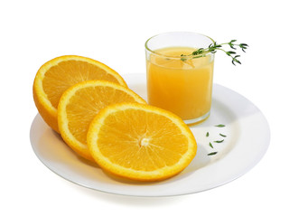 Glass of orange juice and fresh sliced orange on white plate decorated with sprigs of thyme, isolated on white background  