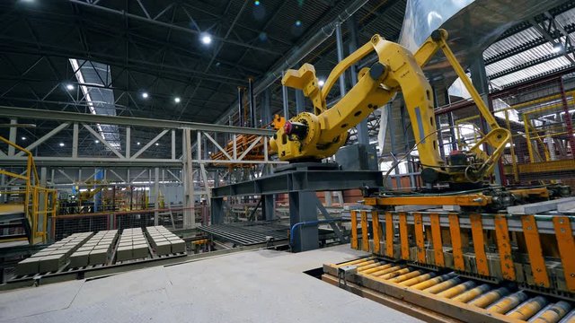 Working arm moves bricks on a line at a modern factory.