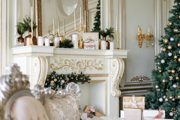 Christmas morning. Classic luxurious apartments with decorated christmas tree and presents. Living with fireplace, columns and stucco.