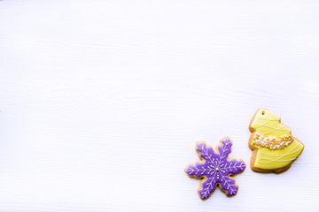 Snowflake and christmas tree gingerbread cookies on white background, top view. Copy space, space for text. Traditional Christmas homemade baking. 