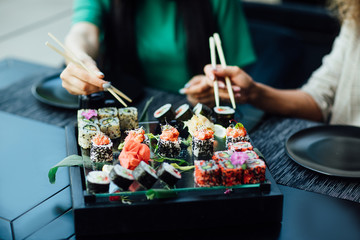 Sushi maki with salmon, surimi crab stick, philadelphia cheese and avocado. And with seaweed, soy sauce and ginger slices next to it. © Тарас Нагирняк