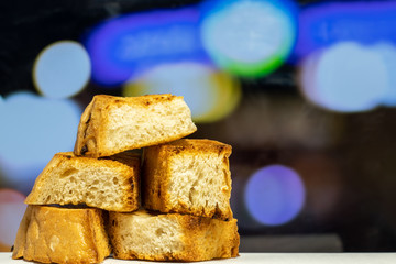 Homemade toasted white bread croutons. Close-up with a blurry color background.