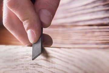 carpenter using  rasp or file handles wooden oak plank