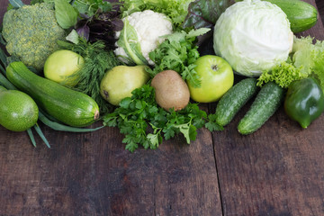 green vegetables and fruit on wooden background healthy diet concept copy space.
