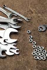 A set of wrenches and nuts lying on the floor. Close-up.