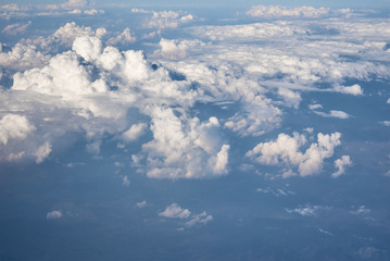 Fototapeta na wymiar Blue cloudy sky, view from the airplane window. Aerial view of cloudscape