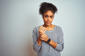 African american woman wearing navy striped t-shirt standing over isolated white background...