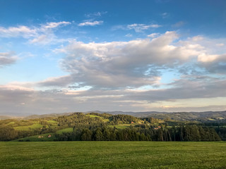 Obraz premium White clouds residing in the sky captured as a time-lapse over a small village Krhova in the Czech Republic Beskydy region clouds projecting over the landscape and soil with shadows during a sunny day