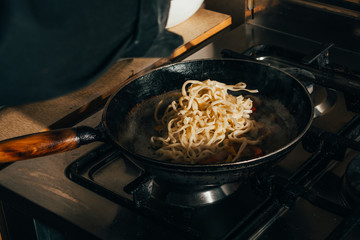 frying spaghetti in a pan