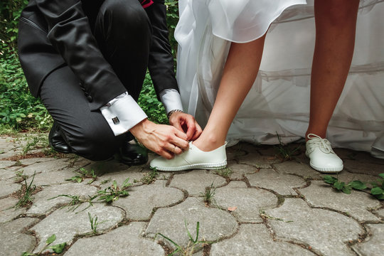 man ties the shoes to the bride. The concept of marriage, family relationships, wedding paraphernalia.
