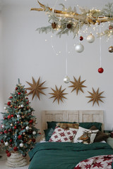 cozy bedroom with a Christmas tree decorated for the new year in red-green tones
