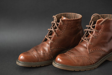 Vintage brown boots on black background, retro shoes