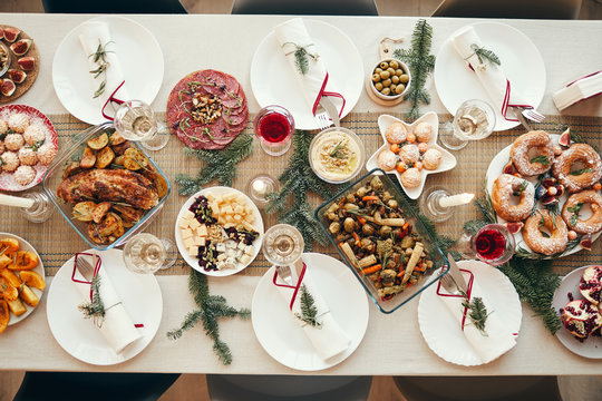 Top view background of beautiful Christmas table with delicious homemade food decorated with fir branches, copy space