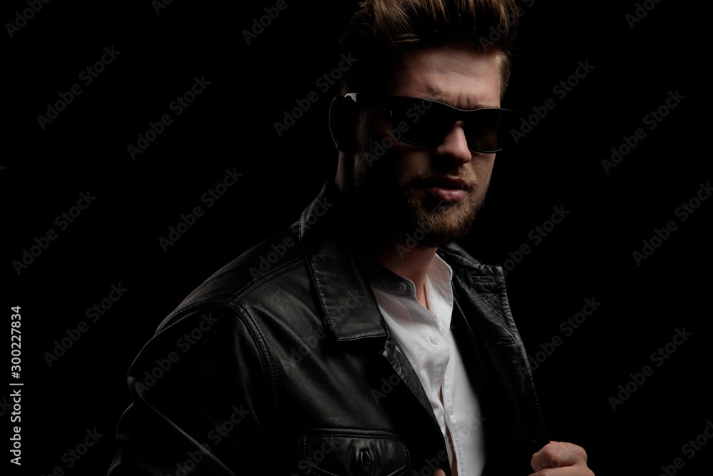 Canvas Prints casual man wearing leather jacket standing and pulling his jacket