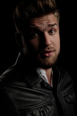 Obraz premium casual man wearing leather jacket staring at camera intrigued