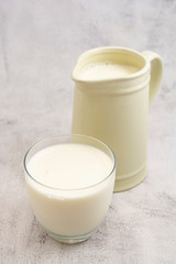 Obraz na płótnie Canvas Jug and glass with milk on bright background isolated. Breakfast drink. Dairy.