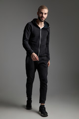 Fototapeta premium casual man wearing tracksuit walking and staring at camera
