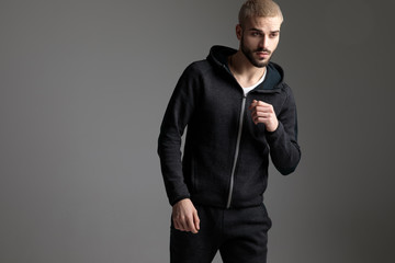 casual man wearing tracksuit standing with loose hands