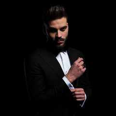 businessman fixing sleeve and staring at camera