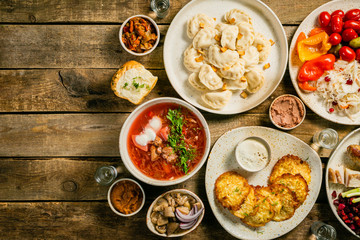 Selection of traditional ukrainian food - borsch, perogies, potato cakes, pickled vegetables, top...
