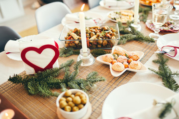 Background image of cozy table setting decorated with fir branches for Christmas banquet focus on...