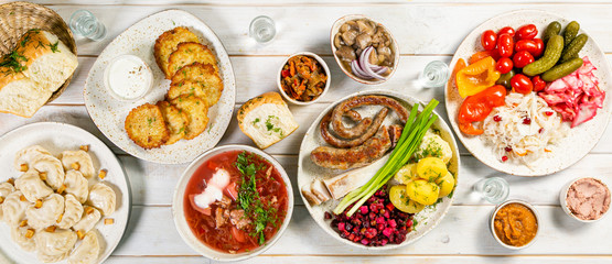 Fototapeta na wymiar Selection of traditional ukrainian food - borsch, perogies, potato cakes, pickled vegetables, top view
