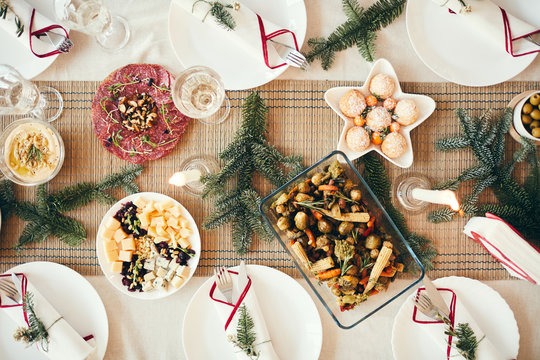 Top view background of cozy table setting decorated with fir branches for Christmas banquet focus on delicious homemade food, copy space
