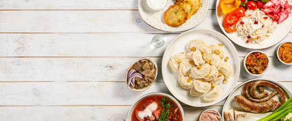 Selection of traditional ukrainian food - borsch, perogies, potato cakes, pickled vegetables, top view